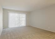 Thumbnail 21 of 29 - an empty living room with a window and blinds