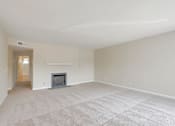 Thumbnail 29 of 37 - A living room with a fireplace and carpeted floor.