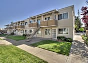 Thumbnail 8 of 33 - Apartment complex with a green lawn in front.