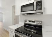 Thumbnail 54 of 92 - A modern kitchen with a stove, oven, and microwave.
