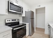 Thumbnail 79 of 92 - A kitchen with white cabinets and a black stove top oven.