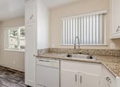 Thumbnail 48 of 51 - A kitchen with a sink, dishwasher, and cabinets.