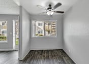 Thumbnail 27 of 40 - A room with a ceiling fan and a window overlooking a building.