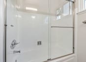 Thumbnail 51 of 52 - A white bathroom with a glass shower door.
