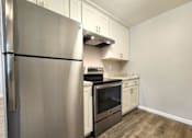 Thumbnail 41 of 50 - A kitchen with a stainless steel refrigerator and wooden flooring.