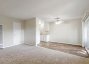 Thumbnail 21 of 37 - A spacious living room with a carpeted floor and a ceiling fan.