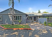 Thumbnail 3 of 31 - A grey building with a red stripe on the driveway.
