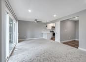 Thumbnail 11 of 53 - an empty living room with a kitchen in the background