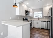 Thumbnail 37 of 53 - a white kitchen with stainless steel appliances and a counter top
