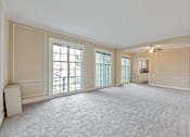 Thumbnail 32 of 42 - A large, empty room with a carpeted floor and a window with a view of a balcony.