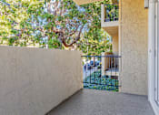 Thumbnail 21 of 32 - A white wall with a tree in the background.