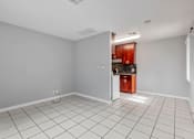 Thumbnail 29 of 38 - A kitchen area with white tiles on the floor and a wooden cabinet.