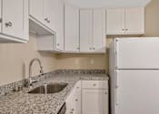 Thumbnail 5 of 13 - a kitchen with white cabinets and a sink and a refrigerator