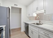 Thumbnail 81 of 92 - A kitchen with white cabinets and a marble countertop.