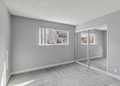 Thumbnail 30 of 40 - A room with a carpeted floor and a large window.