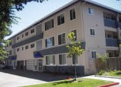 Thumbnail 17 of 31 - a large apartment building with a sidewalk in front of it