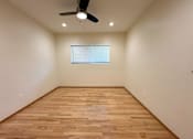 Thumbnail 16 of 33 - A room with wooden flooring and a ceiling fan.