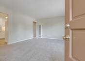 Thumbnail 22 of 34 - A room with a carpeted floor and a door on the right side.
