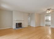 Thumbnail 16 of 37 - A living room with a fireplace and a ceiling fan.