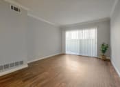 Thumbnail 19 of 35 - A room with wooden floors and a window with blinds.