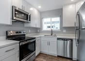 Thumbnail 36 of 53 - a kitchen with white cabinets and stainless steel appliances