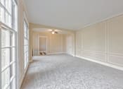 Thumbnail 31 of 42 - A large, empty room with white walls and carpeted floor.