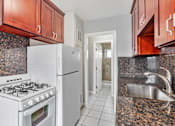 Thumbnail 14 of 38 - A kitchen with a white stove and a white refrigerator.