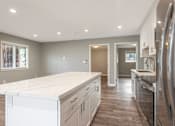 Thumbnail 46 of 62 - A modern kitchen with a white countertop and stainless steel appliances.