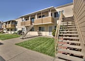 Thumbnail 9 of 33 - Apartment complex with a staircase leading to the second floor.