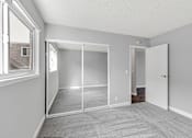 Thumbnail 26 of 40 - A room with a carpeted floor and a sliding glass door.