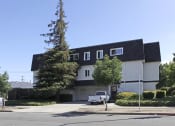 Thumbnail 4 of 15 - a white house with a black roof and a white truck on a street