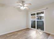 Thumbnail 23 of 37 - A room with a ceiling fan and sliding glass doors.