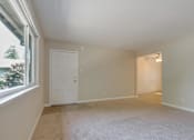 Thumbnail 21 of 34 - A room with a white door and a window with a view of trees.