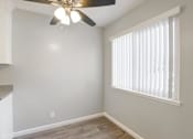 Thumbnail 25 of 27 - A room with a ceiling fan and a window with blinds.
