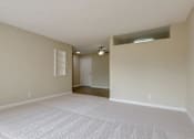 Thumbnail 22 of 33 - an empty living room with white carpet and a door to a closet