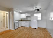 Thumbnail 13 of 38 - A kitchen with white appliances and wooden floors.