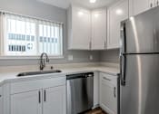 Thumbnail 35 of 53 - a kitchen with white cabinets and a stainless steel refrigerator