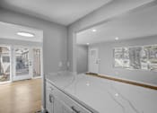 Thumbnail 16 of 31 - A kitchen with a marble countertop and wooden flooring.