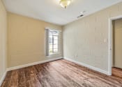 Thumbnail 3 of 21 - A room with wooden floors and a window.