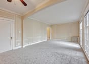 Thumbnail 30 of 42 - A spacious room with a carpeted floor and a ceiling fan.