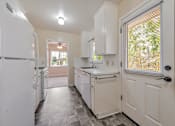Thumbnail 12 of 29 - A kitchen with white appliances and cabinets.
