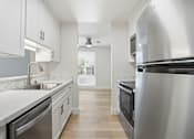 Thumbnail 80 of 92 - A modern kitchen with stainless steel appliances and white cabinets.