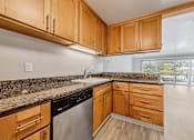 Thumbnail 3 of 92 - A kitchen with wooden cabinets and granite countertops.