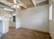 Thumbnail 23 of 32 - A room with a ceiling fan and wooden floors.