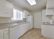 Thumbnail 19 of 37 - A kitchen with white cabinets and appliances.