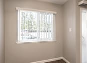 Thumbnail 24 of 27 - A room with a window and a white door.