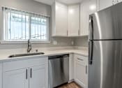 Thumbnail 27 of 53 - a kitchen with white cabinets and a stainless steel refrigerator