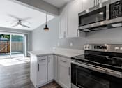 Thumbnail 34 of 53 - a kitchen with white cabinets and black appliances