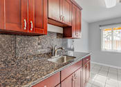 Thumbnail 13 of 38 - A kitchen with brown cabinets and a granite countertop.