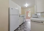 Thumbnail 28 of 29 - A kitchen with white appliances and a tiled floor.